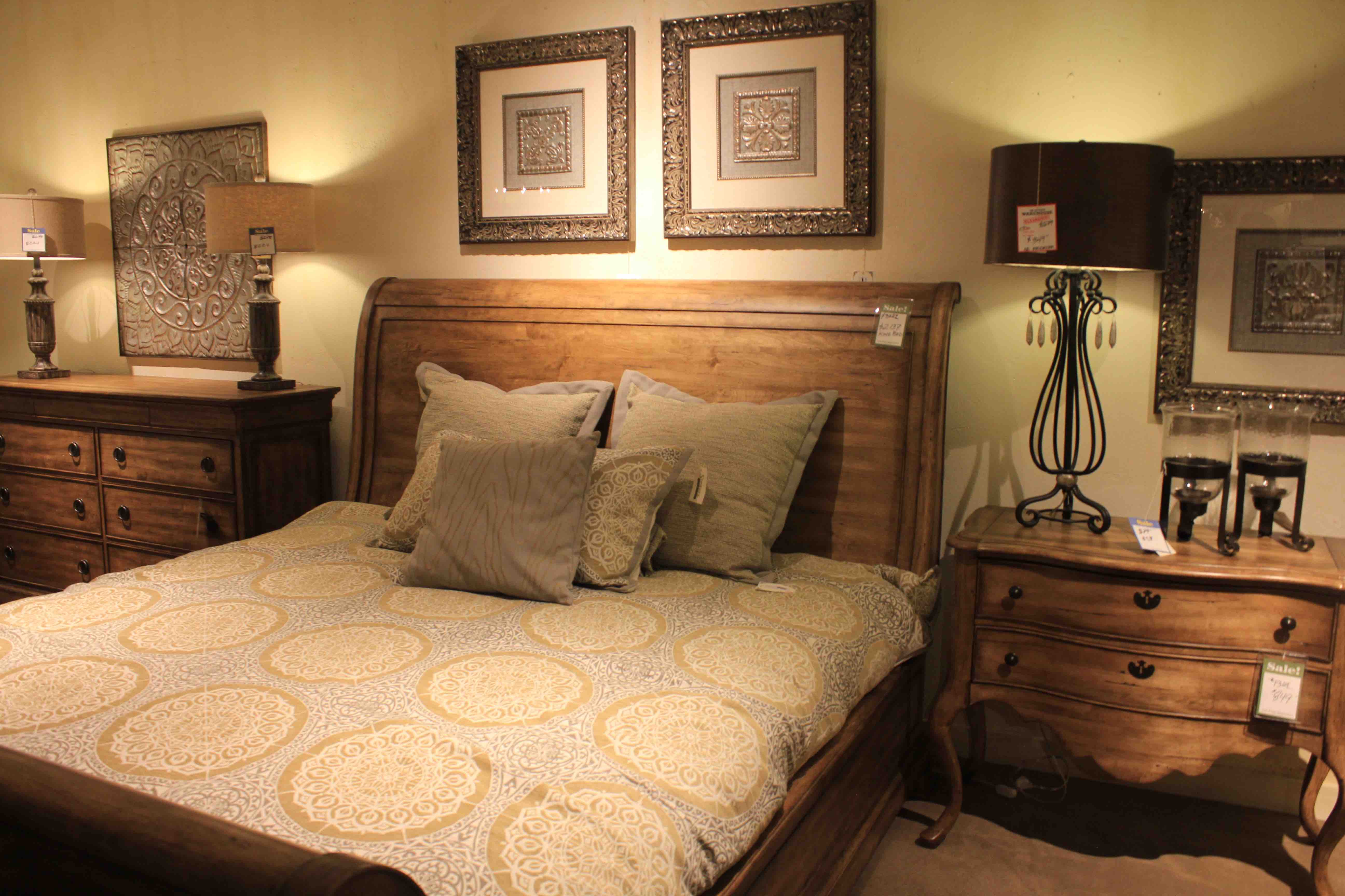 large bed with an orange flowered comforter and tan pillows